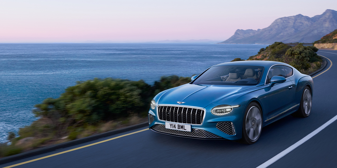 Bentley Vilnius New Bentley Continental GT Azure coupe in Light Windsor blue paint with 22 inch Azure wheels and chrome grill, driving dynamically by the sea