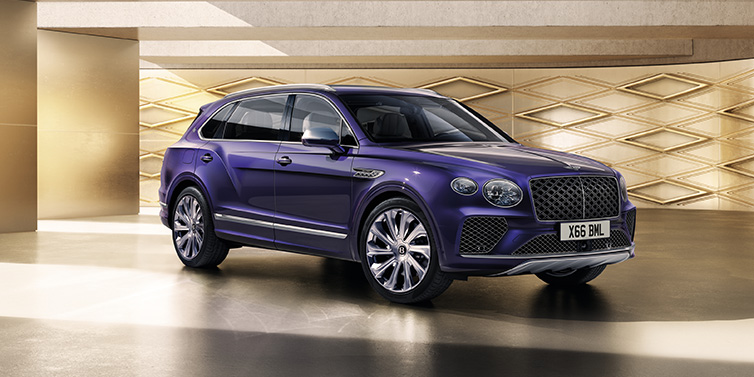 Bentley Vilnius Bentley Bentayga Extended Wheelbase Mulliner SUV front three quarter in Tanzanite Purple paint with a gold patterned background